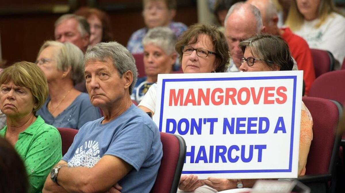 Several signs were held by people in the room as Aqua by the Bay development proposal goes before the Manatee County Commissioners Tuesday.