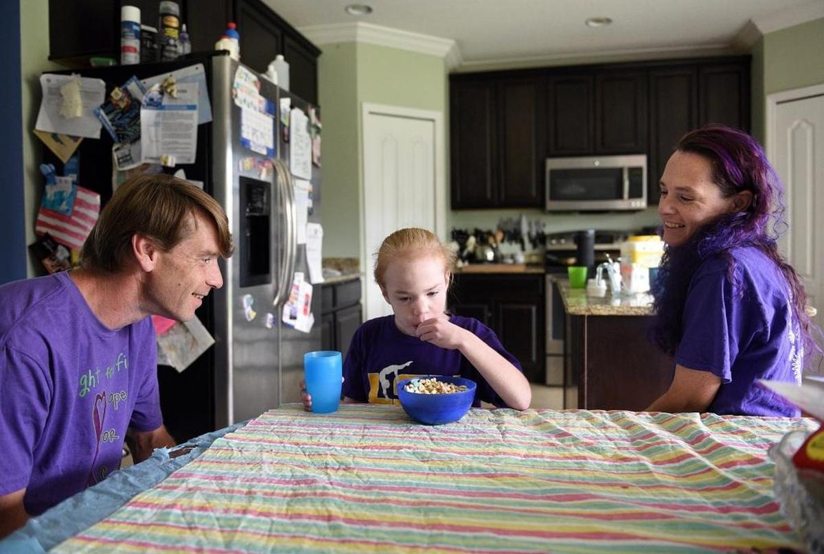 Randy Humphrey plays with his daughter, Fiona, as mom, Catriona, smiles. Fiona was diagnosed with Sanfilippo syndrome; the family struggled for a long time finding the right diagnosis.