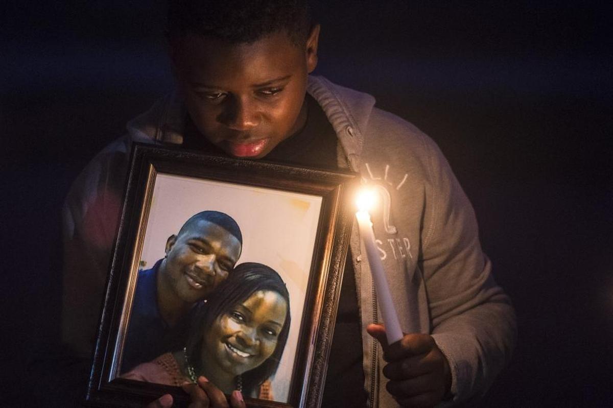 Zakai Cherenfant, 11, cries as he holds a candle and a picture of his deceased step-father, Dequan Randolph and his mother, Rosemary Randolph, during a candlelight vigil for Dequan Randolph on Thursday evening, November 10, 2016 in Bradenton. Family and friends gathered for a memorial to Randolph, who was killed on Thursday, November 3, at the site of the shooting to share prayers and memories.