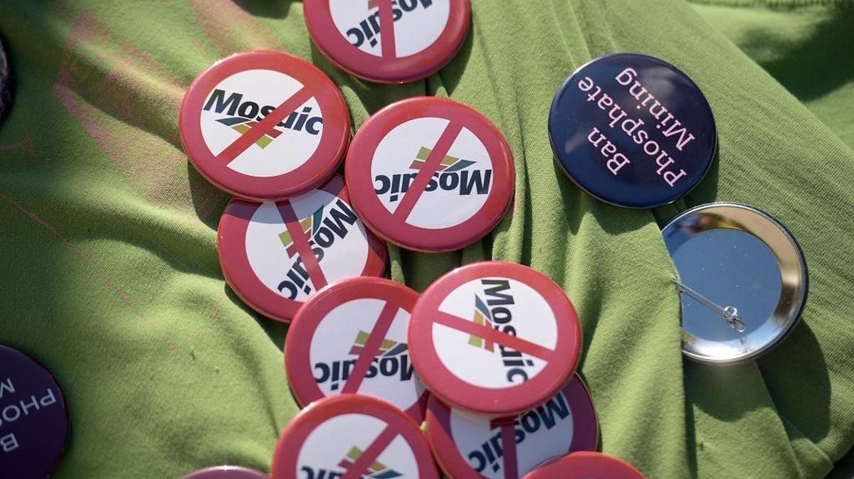 A protestor has a board holding buttons against Mosaic and phosphate mining on the third day of the Manatee County Commission public hearing on Mosaic's request.