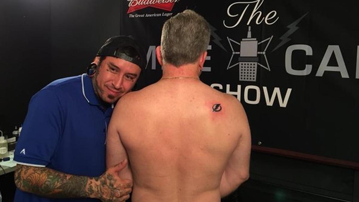 Live on Tampa’s 102.5 “The Bone” radio station, Bradenton mayoral candidate Warren Merriman on Wednesday got a tattoo on his back of the Tampa Bay Lighnting’s logo.