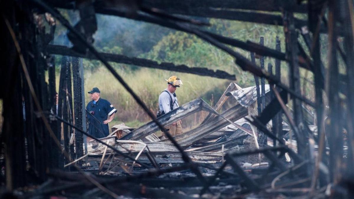 Manatee County firefighters sift through rubble to make sure nobody was trapped after an abandoned flea market in Oneco caught fire, displacing several homeless people on Saturday.