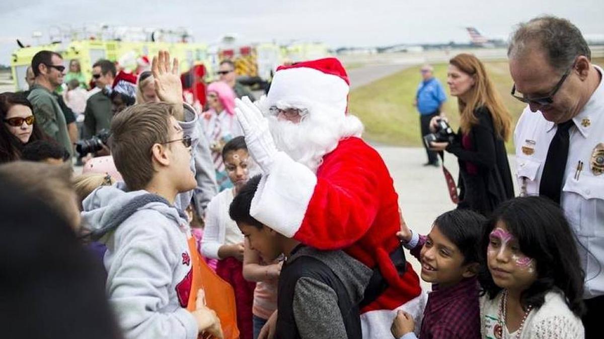 Santa Claus greets the crowd after landing in a Sheriff's helicopter during the 31st Annual "Flight to the North Pole" at at the Sarasota Bradenton International Airport Fire Department on Thursday morning, December 8, 2016 in Sarasota. Hundreds of ill children were treated to Santa's visit in addition to free food, horse rides, crafts and live musical performances.