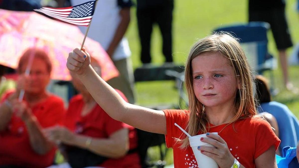 A young fan waves the American Flag during the 2015 Fourth of July festival in Palmetto.