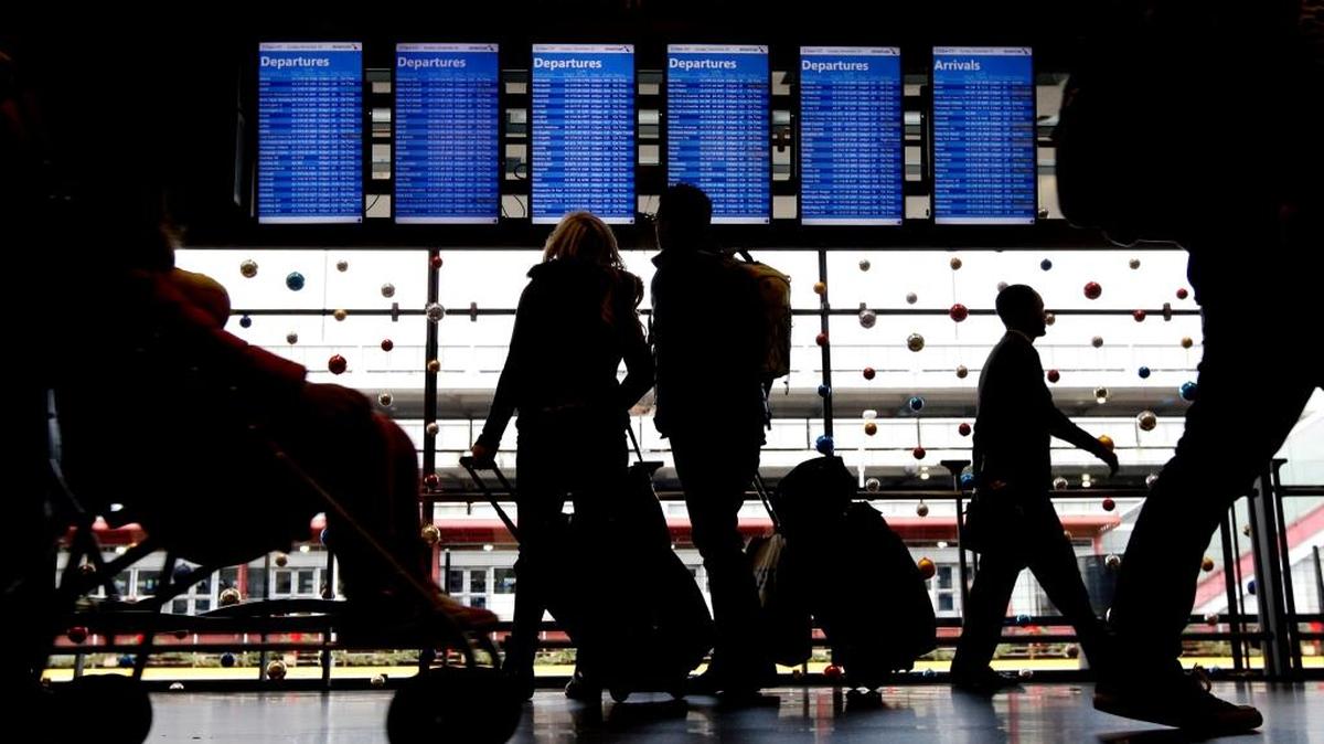 FILE - In this Nov. 29, 2015 file photo, travelers walk to their gates at O'Hare International Airport in Chicago. Due to expected snow up north, thousands of flights have been delayed or canceled for Monday and Tuesday travelers. Some airlines are waiving ticket-change fees, according to the AP. (AP Photo/Nam Y. Huh, File)