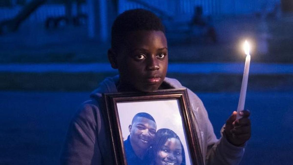 Zakai Cherenfant, 11, holds a picture of his deceased step-father, Dequan Randolph and his mother, Rosemary Randolph, during a candlelight vigil for Dequan Randolph on Thursday evening, November 10, 2016 in Bradenton. Family and friends gathered for a memorial to Randolph, who was killed on Thursday, November 3, at the site of the shooting to share prayers and memories.