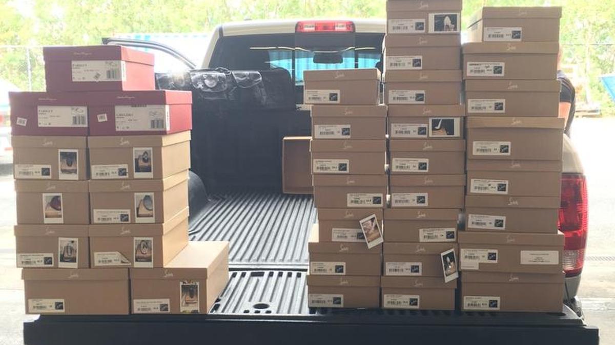 Detectives haul away boxes of Louis Vuitton shoes bought by corrupt Miami International Airport manager Ivan Valdes.