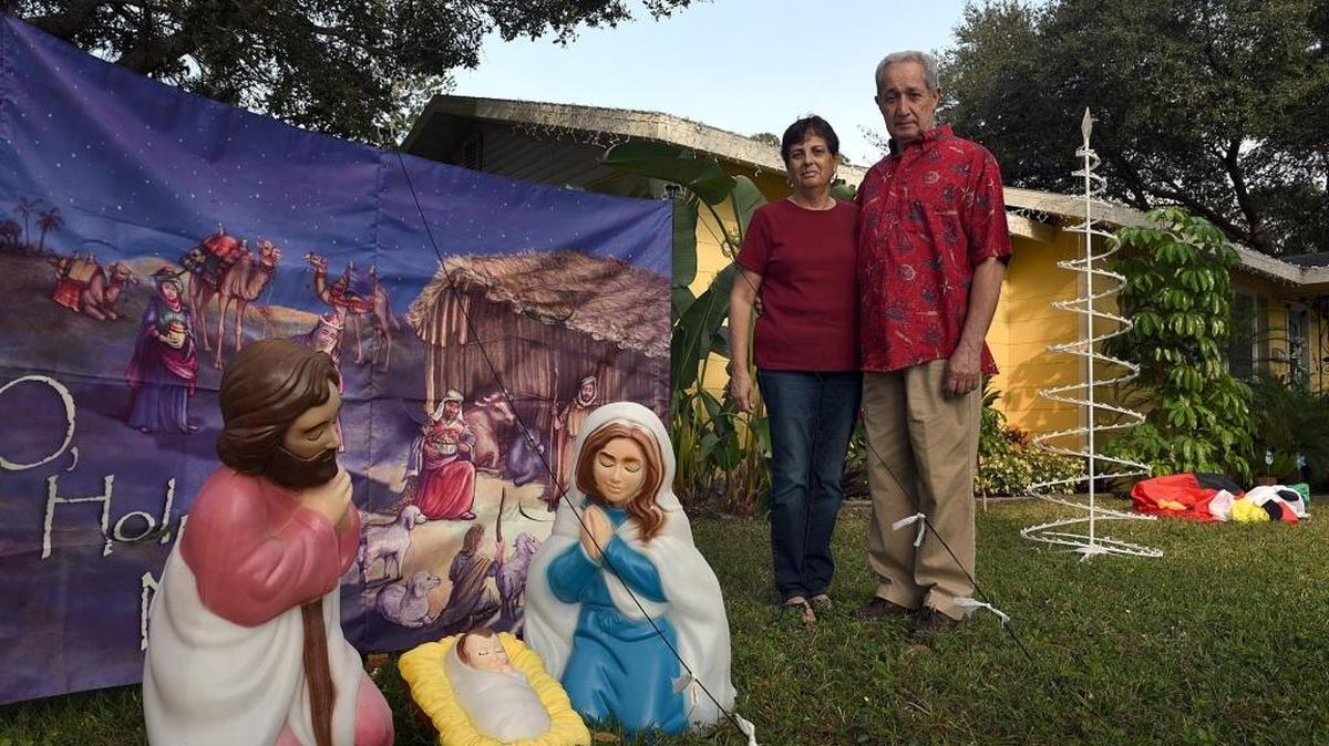 Millie and Luis Rodriguez stand with the nativity scene in their front yard.