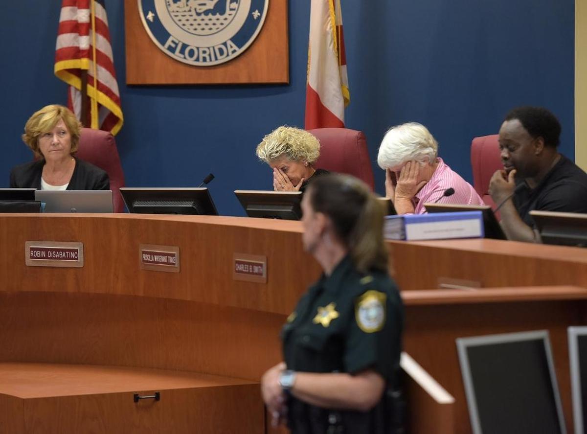 County Commissioners Robin DiSabatino and Priscilla Whisenant Trace put their heads in hands Friday as Charles Smith addresses the room during a special meeting Friday to discuss security ahead of the planned march and protests on Monday.