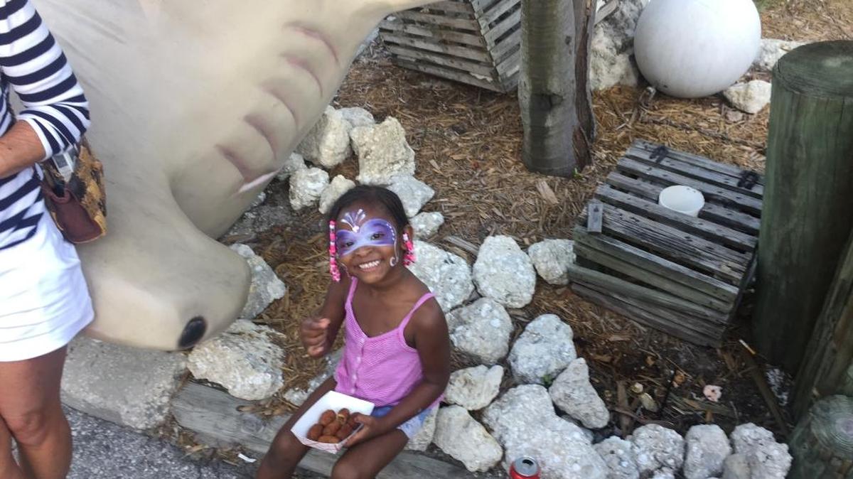 Ny’lah Redding, 3, of Bradenton, enjoys a snack at the Cortez Stone Crab Festival on Saturday.