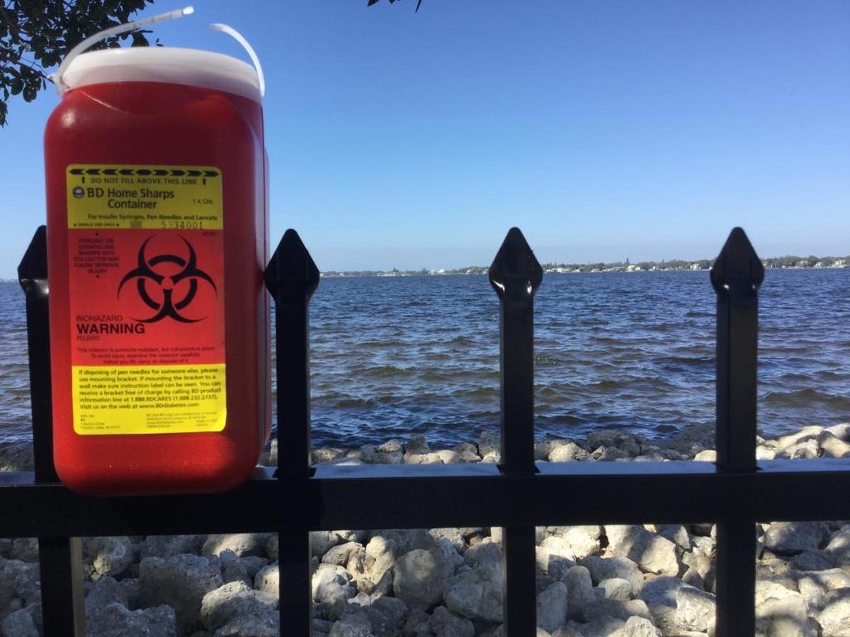 There are almost 100 syringes in this container that Point Pleasant resident Ryan Snyder said he has collected from this small strip of land on the Manatee River over the past year. Snyder acquired the property to clean it up and protect his neighborhood from unwanted activities, but others in the neighborhood are outraged.