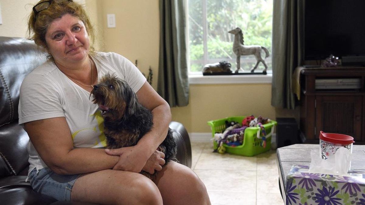 Selma Swensk, a widowed mother who was victim to the flood, holds her dog, Daisy, tearfully as she recounts the days since her rented home flooded.