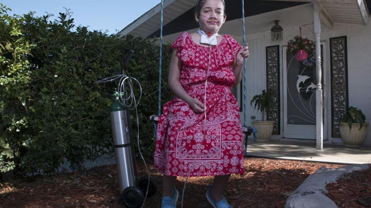 Sage McCue, 11, sits on a swing in front of her home in Palmetto last week. Just recently, she returned from Johns Hopkins All Children’s Hospital in St. Petersburg after a nearly four-month stay.