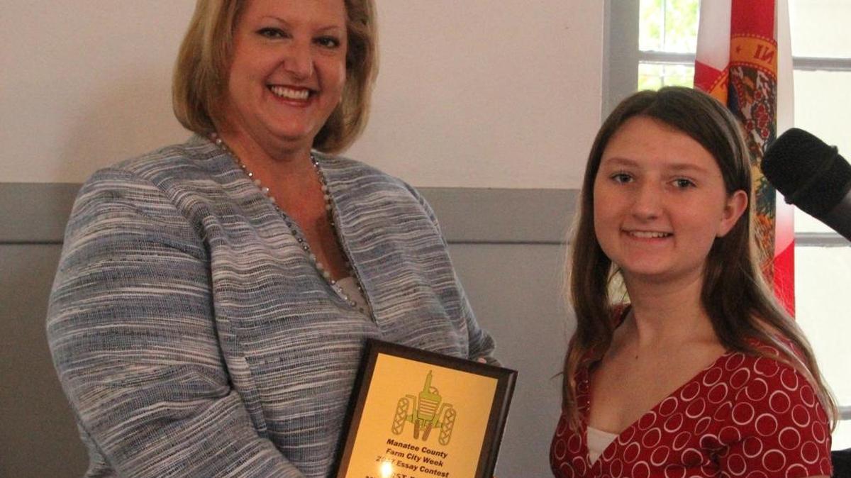 Kelli Kennedy of the Manatee School District presented the first-place award for Farm City Week Essay to Nolan Middle School student Mackenzie Sisson on Thursday.