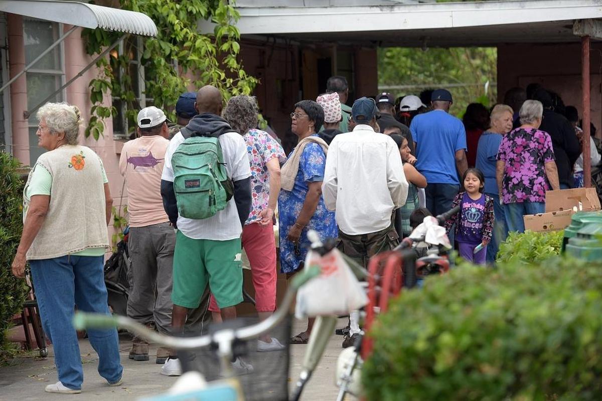 A long line forms at the Mt. Carmel Resource Center where the Palmetto Police Department teamed up with the Mayors’ Feed the Hungry to collect food and distribute it to needy members of the community Tuesday morning. Other volunteers included high school students, Chief William Tokajer of Holmes Beach and Sheriff Rick Wells.