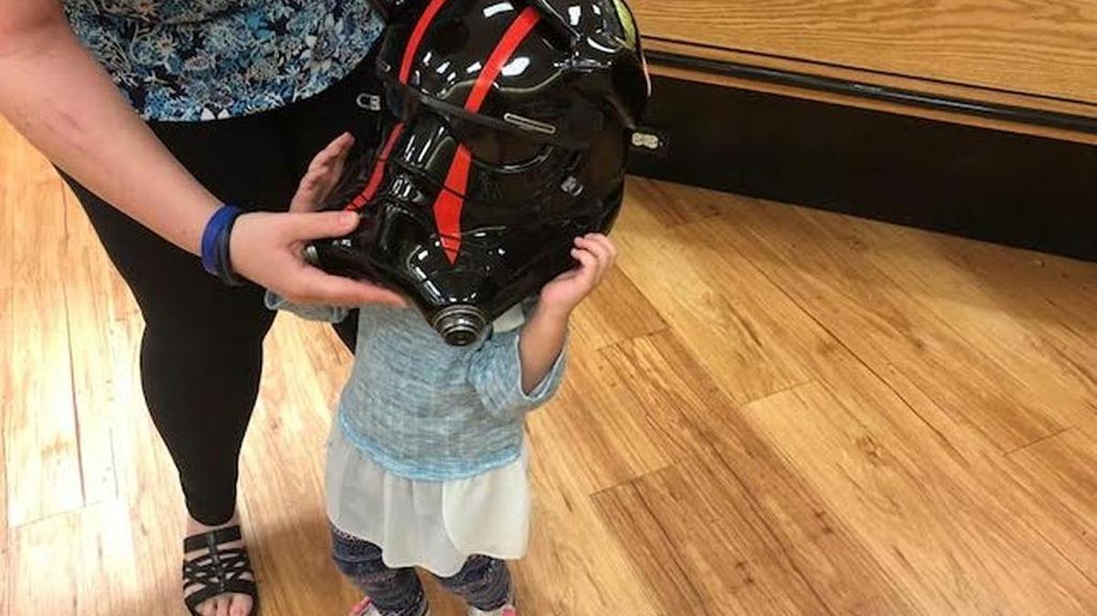 Todd Hand’s 3-year-old daughter, Nicole, tries on her father’s new “Star Wars” helmet at Winn-Dixie in Bradenton on Tuesday, Jan. 9.