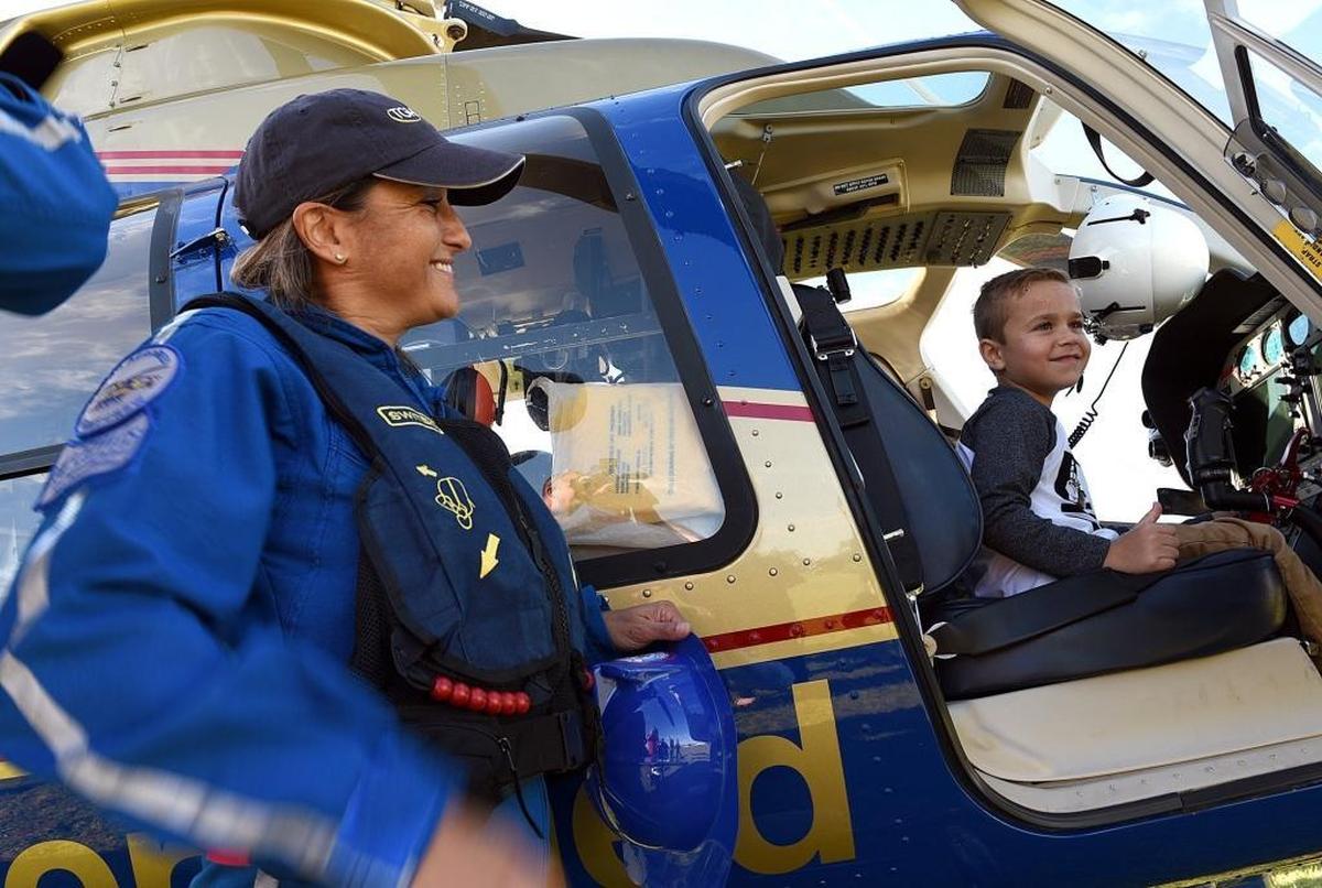 Aeromed flight nurse Trish Hamilton smiles as Caden McClusky, 7, sits in the pilot seat of a helicopter at the Manatee County Public Safety Complex on Monday. Caden reunited with the safety crews that rescued him and his father after a serious car accident Nov. 7 in Lakewood Ranch.