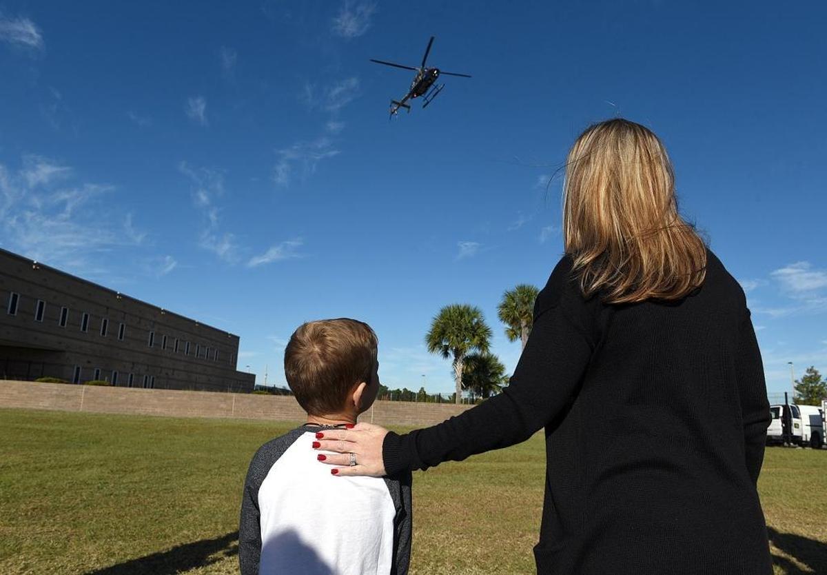 Caden McClusky, 7, and his mother, Katie Dean, watch as the helicopter that rescued him from a serious car accident prepares to land at the Manatee County Public Safety Complex on Monday. Caden met and thanked the emergency crews who helped him and his father after a serious car accident Nov. 7.