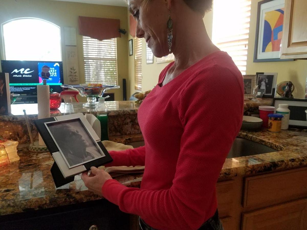 Ellen Gerth admires a photograph of her mother, Ina Gross, on Wednesday in the wake of her brother’s arrest for their mother’s murder.