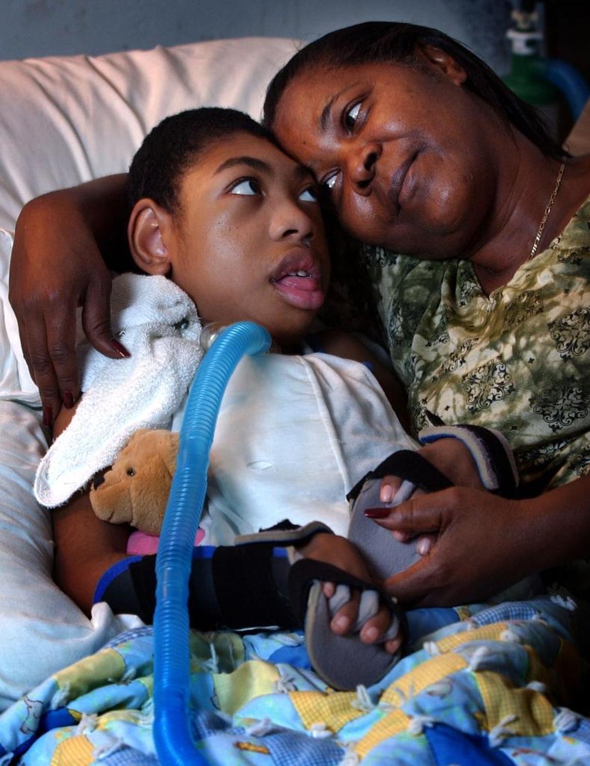 Margaret Coakley-Dyke cuddled with her grandson, Julius Dykes, then-10, in her Fort Lauderdale home in this March 2003 file photo. Her 18-year-old daughter, Lisa, was stabbed to death while Julius was in utero in 1993.