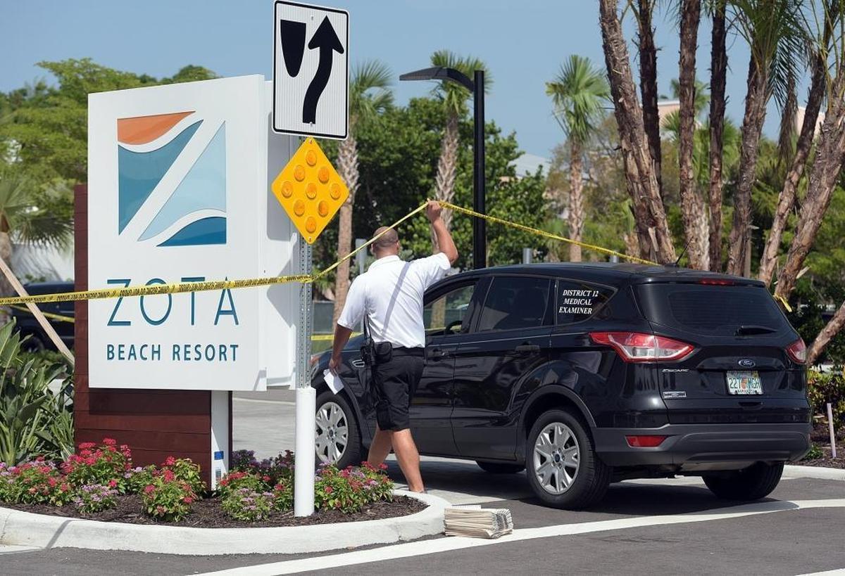 A law enforcement officer lifts the crime scene tape for the arriving medical examiner at a double homicide investigation at the luxury Zota Beach Resort on Longboat Key.
