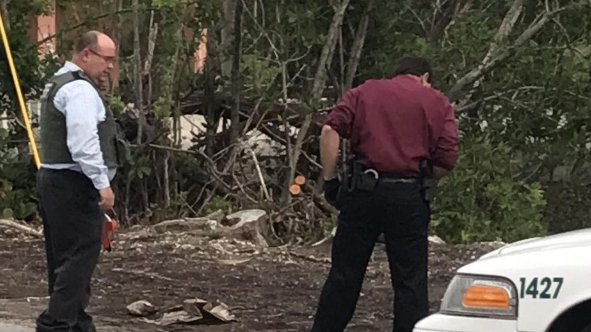 Monroe County Sheriff’s Office detectives look for shell casings beside a canal in Islamorada after someone fired at least 12 bullets at a crocodile Monday, Nov. 13.
