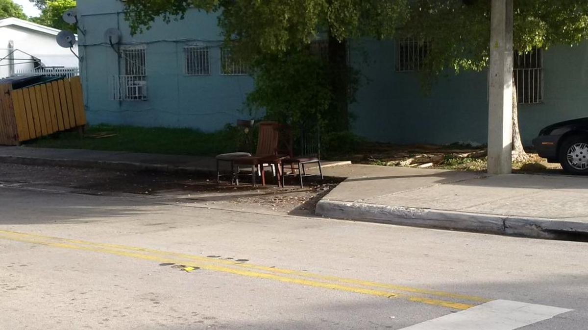 A cluster of plastic chairs near the scene where three people were shot in Coconut Grove late Monday
