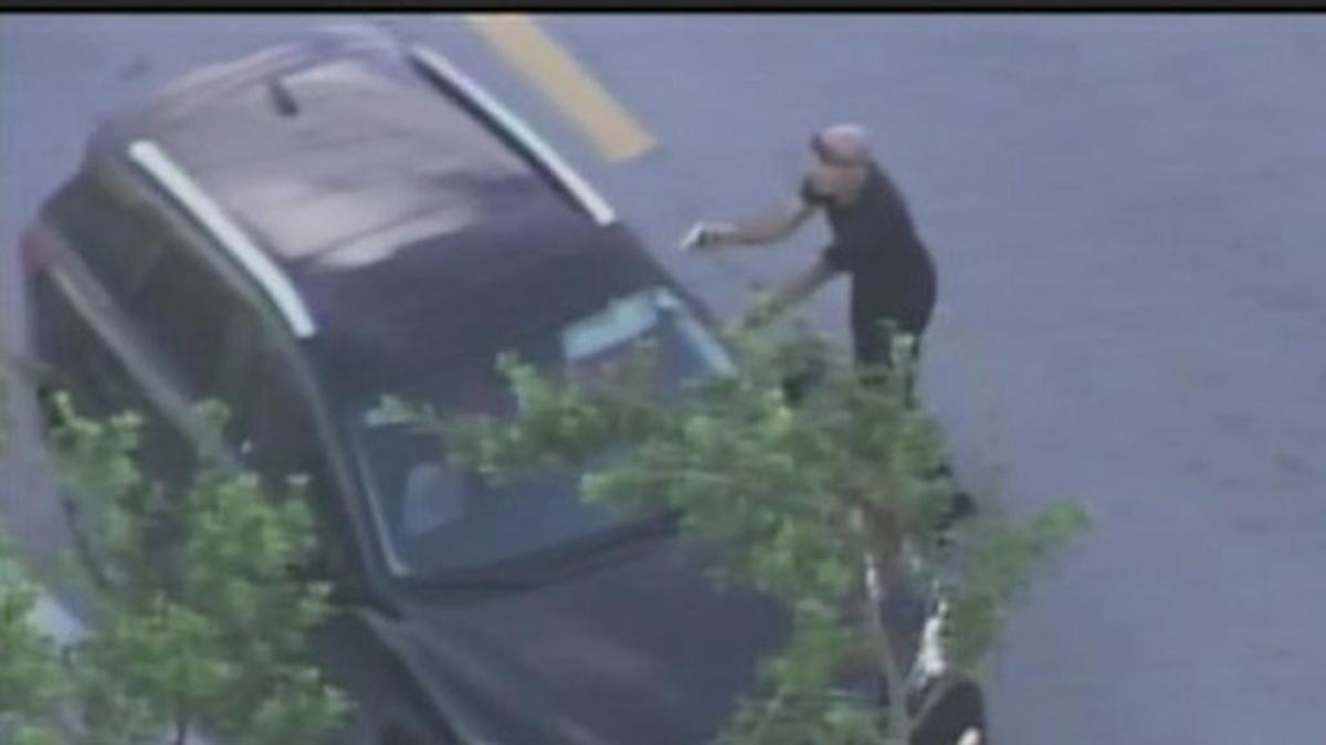 A man who led police on a chase carjacked a vehicle in the middle of the chase. Here he is holding a gun at another driver in the midst of that carjacking.