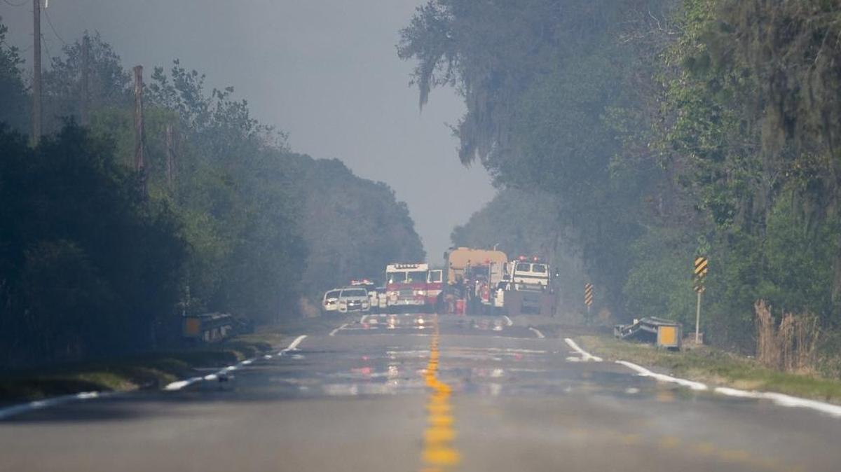 Emergency crews respond March 4 to the scene of a fatal plane crash that left two dead and caused a brush fire in Duette.