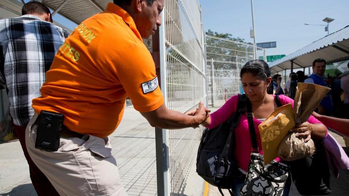 A Mexican migration agent offers a hand to a Cuban migrant as she arrives to Ciudad Hidalgo, Mexico, on the border with Guatemala on Jan. 13. After more than three months stranded in Costa Rica, 180 of the 8,000 Cuban migrants began their long-awaited trip north, toward the U.S. border.