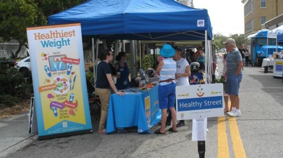 A vendor dispenses information during a previous “Beats @Healthy Street Health Fair” at the Bradenton farmer’s market in downtown Bradenton.