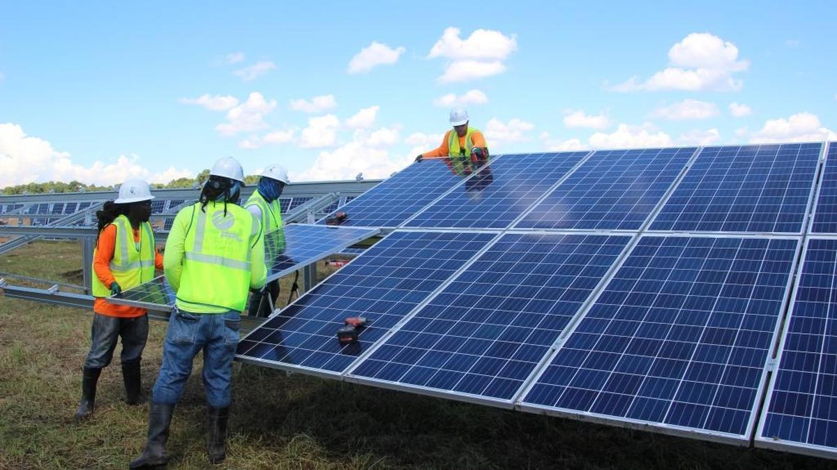 Workers move a solar panel into place at FPL's Manatee Solar Energy Center.