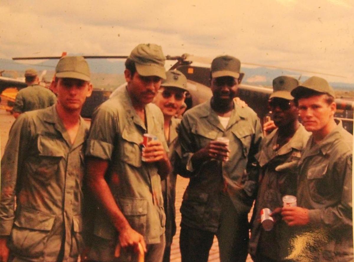 Tony Morton, second from left, used a cane for a few weeks after being injured in a helicopter crash.