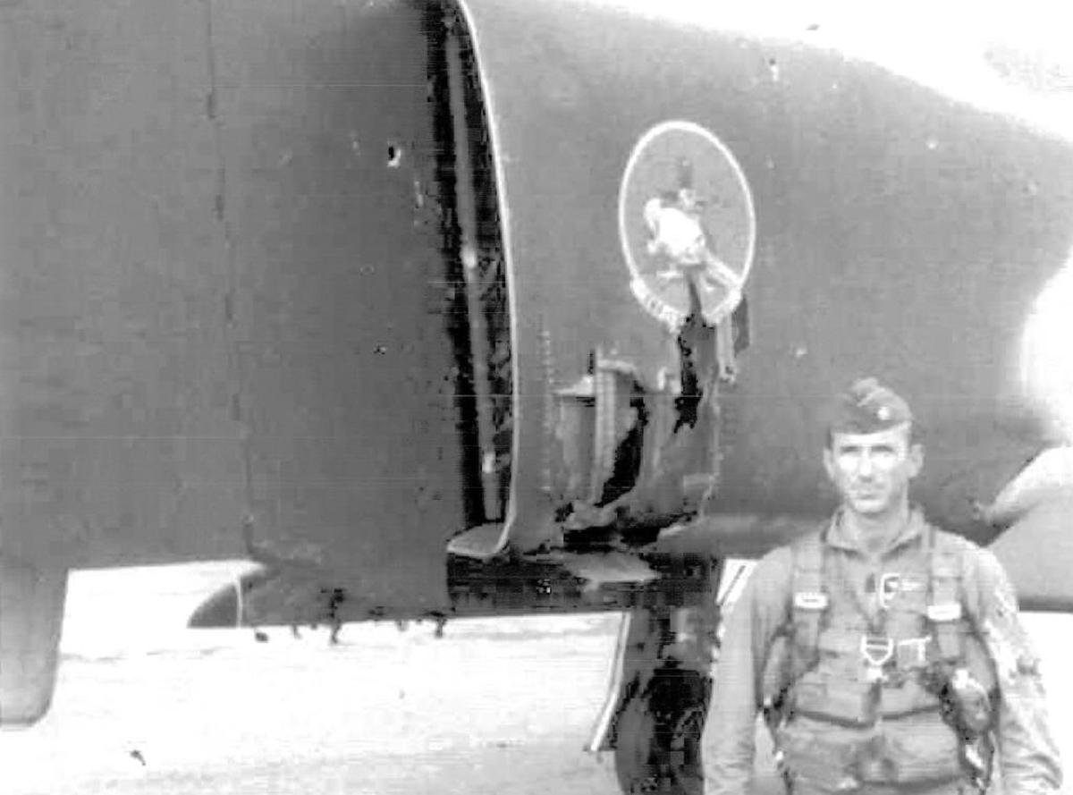 Major Larry Bustle stands with his F4 Phantom fighter with combat damage in Da Nang, Vietnam, in 1968.