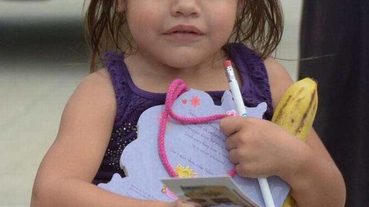 The TCC store in Bradenton will be distributing 220 free backpacks this Sunday. In this file photo, Bernice Gutierrez, holds on to giveaways from the Kiwanis Club’s 2014 Christmas in August event at McKecknie Field in Bradenton.