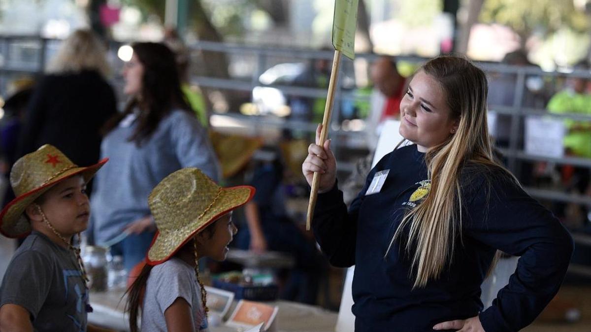 Katie Cardinale, a Palmetto High volunteer, works with Manatee County third graders gathered at the Manatee County Fairgrounds for Ag-Venture, learning all about the farm.