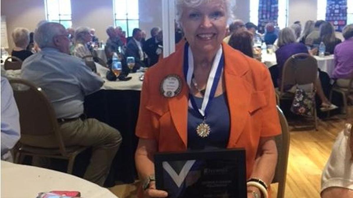 Karen Carpenter hold her Kiwanis Club award.