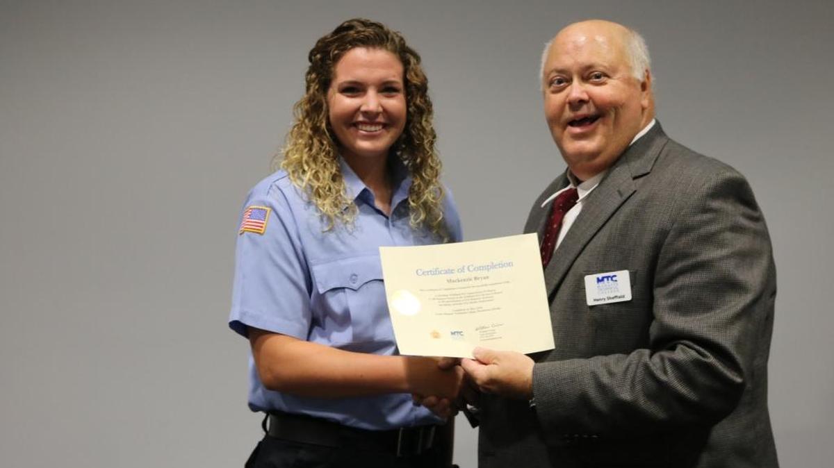 Manatee Technical College Fire Academy graduate Mackenzie Bryan and academy coordinator Chief Henry Sheffield at the graduation ceremony.