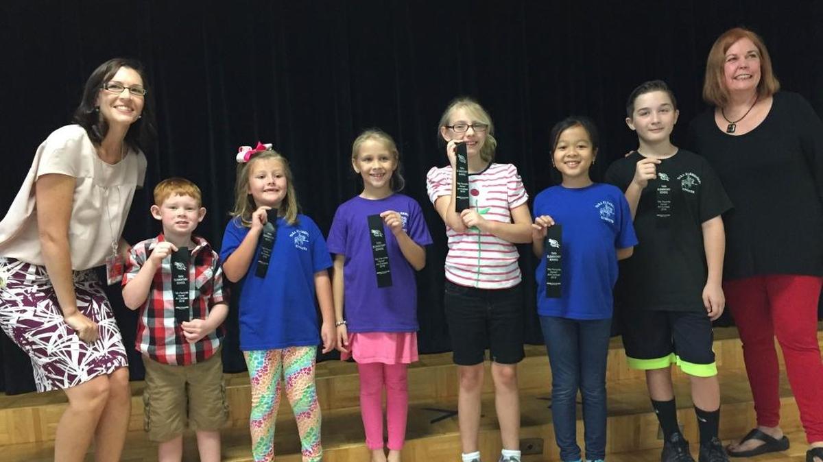Tara Elementary School principal Laura Campbell, left, and art teacher Pat Knowlton, right, pose with grade-level student winners after the My Favorite Home contest.