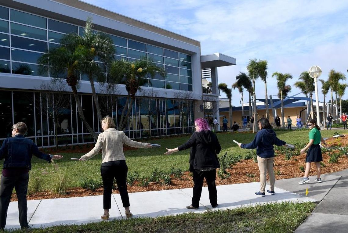 Staff and students line up to pass books from the old library to the new one at State College of Florida's book brigade event Monday.
