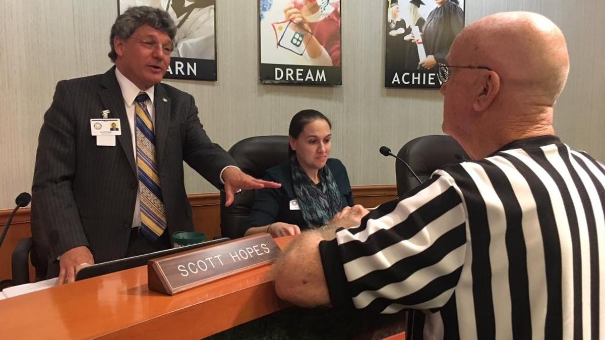 Manatee School Board Chairman Scott Hopes, left, talks to community activist Norm Nelson, right, during Tuesday’s board meeting. At center is school board member Gina Messenger.