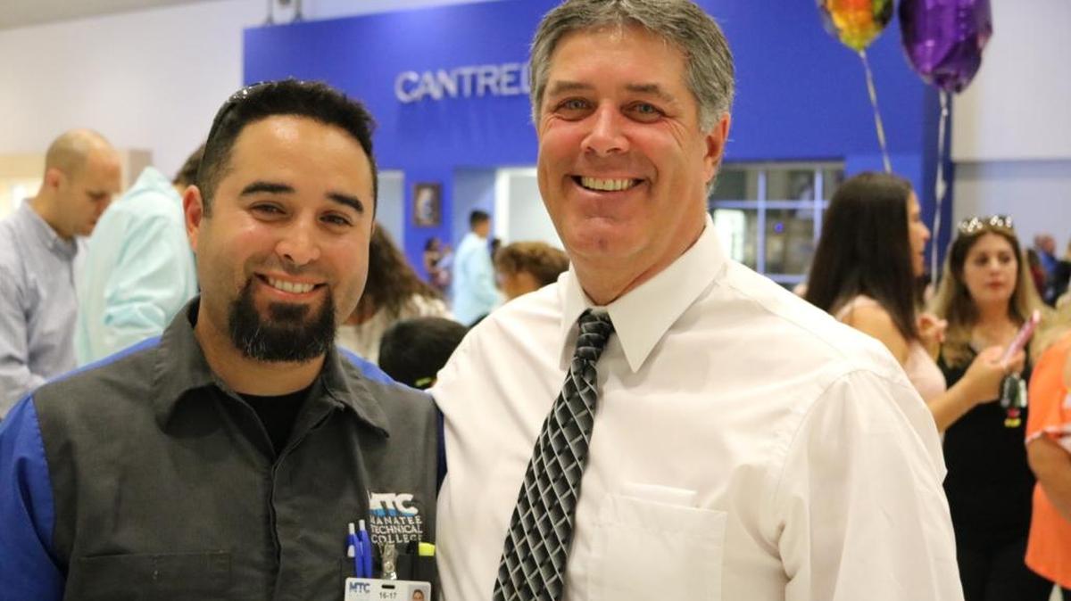 James Rousey congratulates his father Richard Rousey, who was inducted into the National Technical Honor Society during a ceremony at Manatee Technical College on Tuesday.