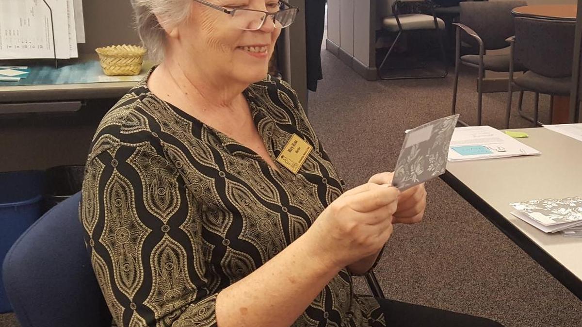 Mary Scott Ross, a mentor with Take Stock in Children, reads a thank-you note from one of the organization’s 35 new scholars.