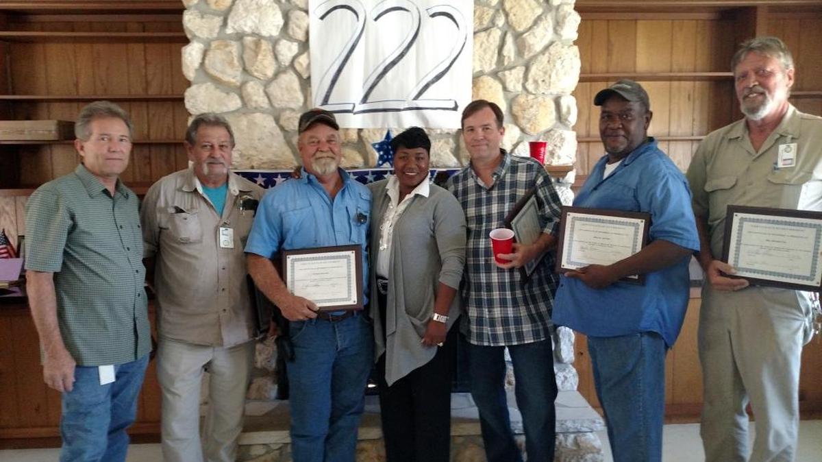 Six maintenance and operations employees who are retiring pose with Superintendent Diana Greene