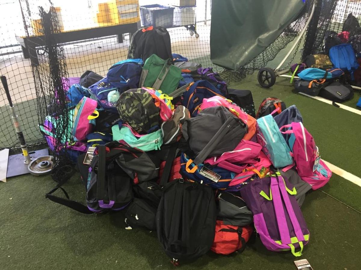 A pile of completed backpacks, waiting to be given to homeless children. The bags were filled by volunteers at LECOM field on Friday morning in preparation for Saturday’s Christmas in August event.