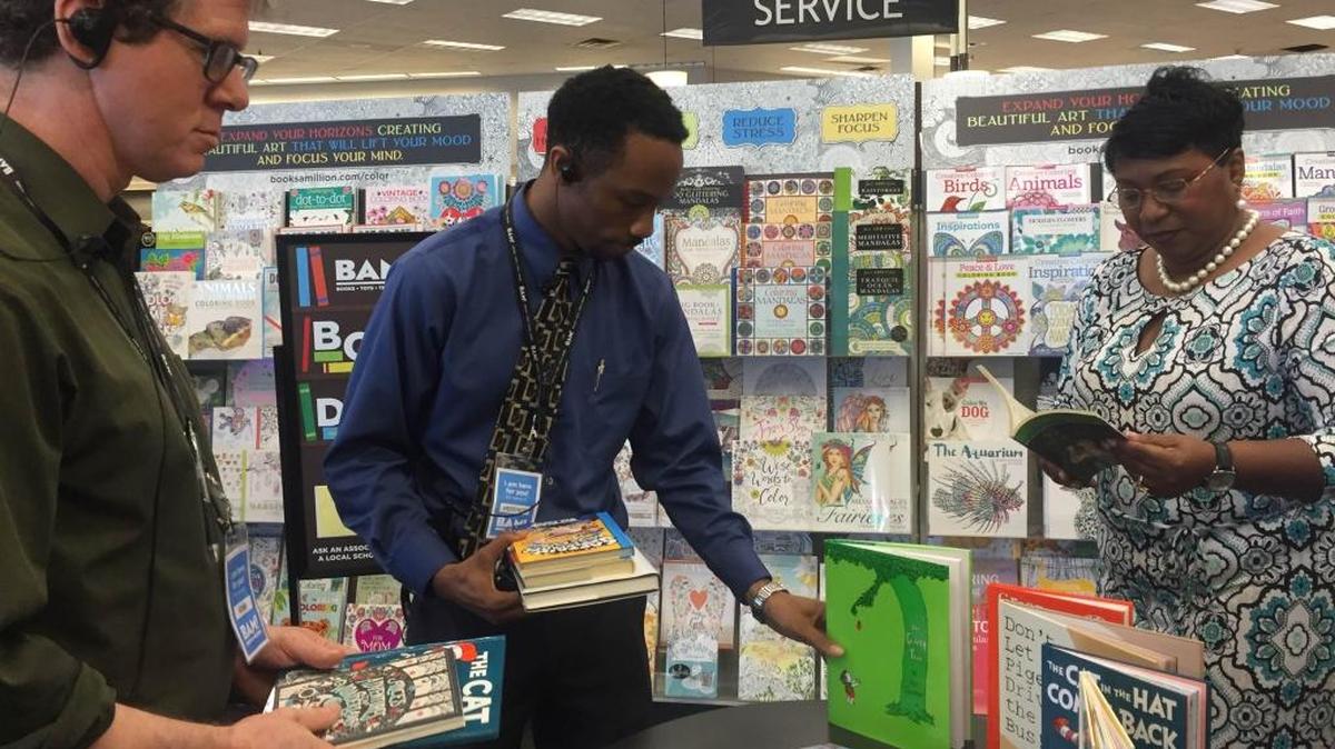 Adam Orenstein, manager at Books-A-Million, Federico Dixon, general manager at Books-A-Million and Manatee County School District Superintendent Diana Greene look over books that were donated to elementary and middle schools Monday.