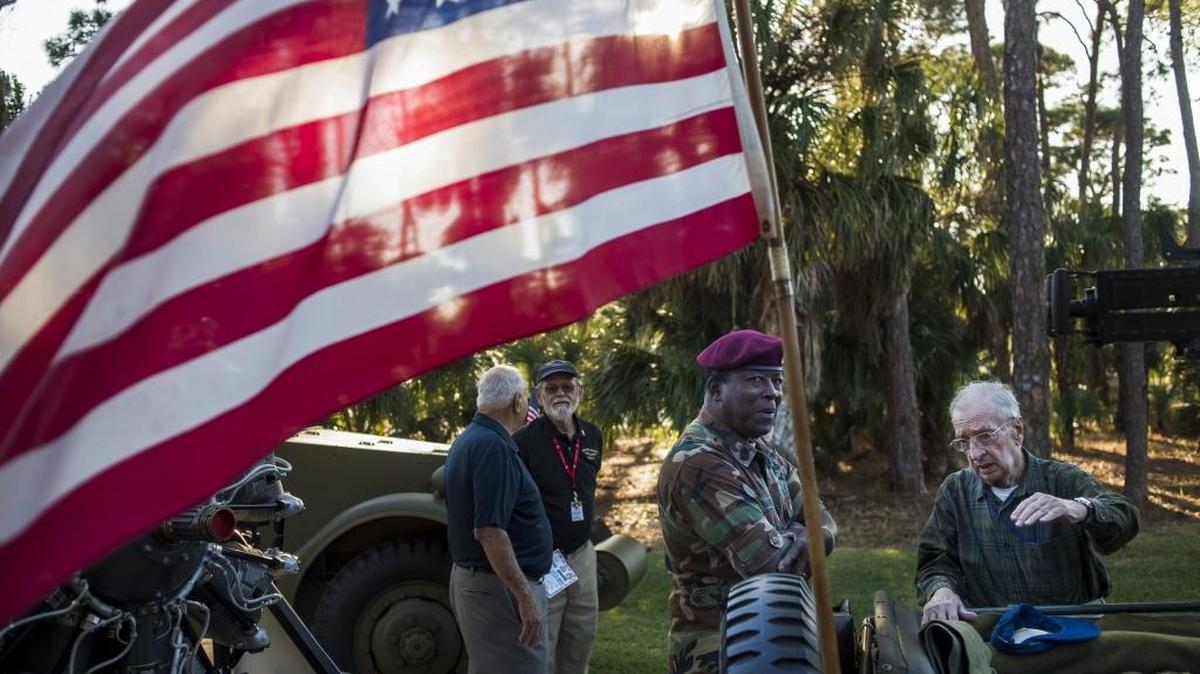 An American Flag blows in the breeze as veterans share stories around pieces of machinery used in combat as local veterans and supporters of the military gathered Wednesday at the University of South Florida Sarasota-Manatee to commemorate the 75th anniversary of the attack on Pearl Harbor.