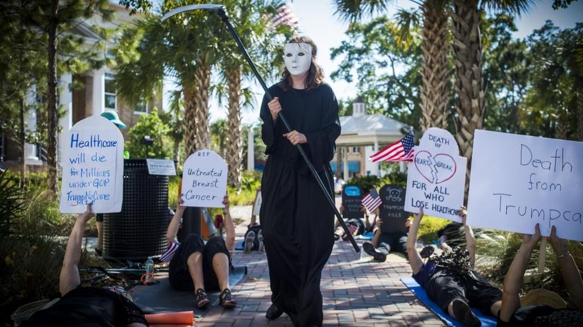 Liv Coleman dresses as the grim reaper as activists gather for a “Die In” protest outside U.S. Rep. Vern Buchanan’s office on Thursday in Bradenton. About two dozen people gathered to protest Buchanan’s vote to pass the Republican backed American Health Care Act out of the House of Representatives.
