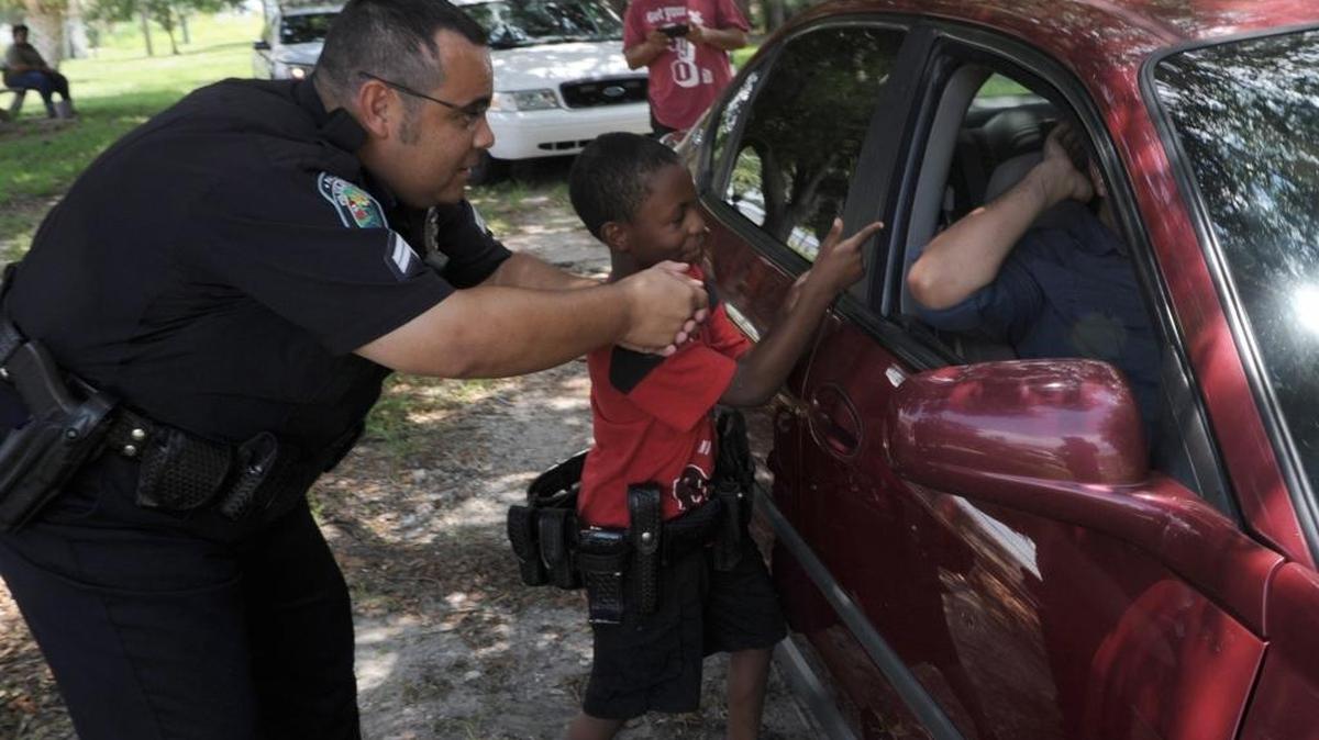 Cpl. Chris Metzger helps Elijah McKenzie, with LightWay Ministries, as he makes a traffic stop and finds a firearm in the vehicle, during Palmetto Police Department's Youth Academy on Friday in Palmetto.