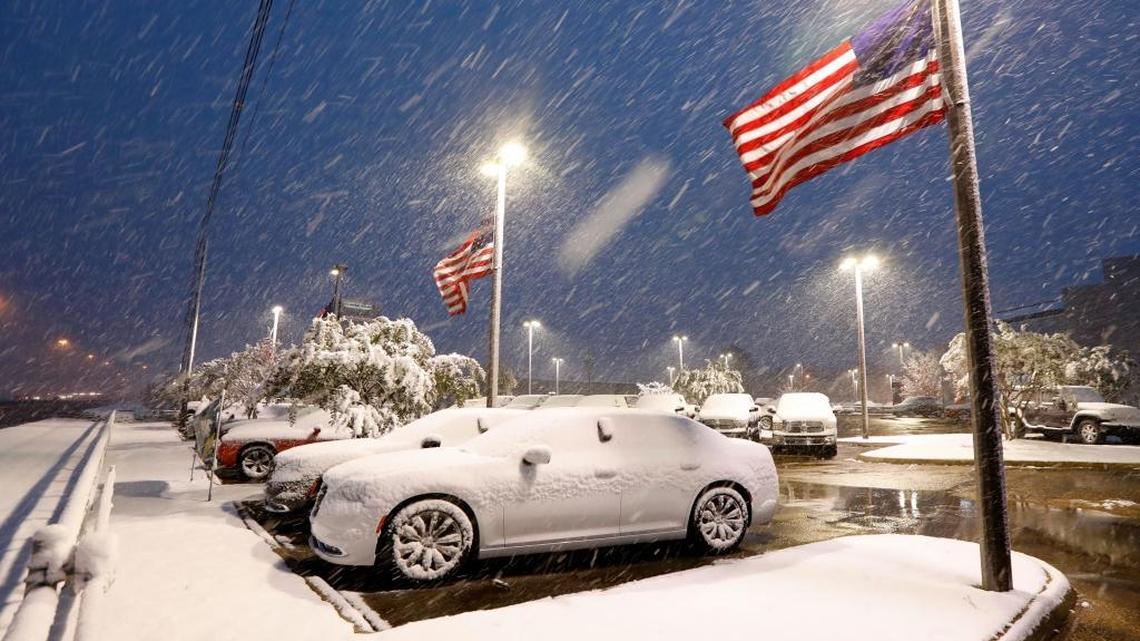 American flags wave as snow falls, blanketing vehicles in a car sales lot on Friday in Jackson, Miss. The forecast called for a wintry mix of precipitation across several Deep South states, including the Florida Panhandle. Fortunately, the flakes will fall far short of Manatee.